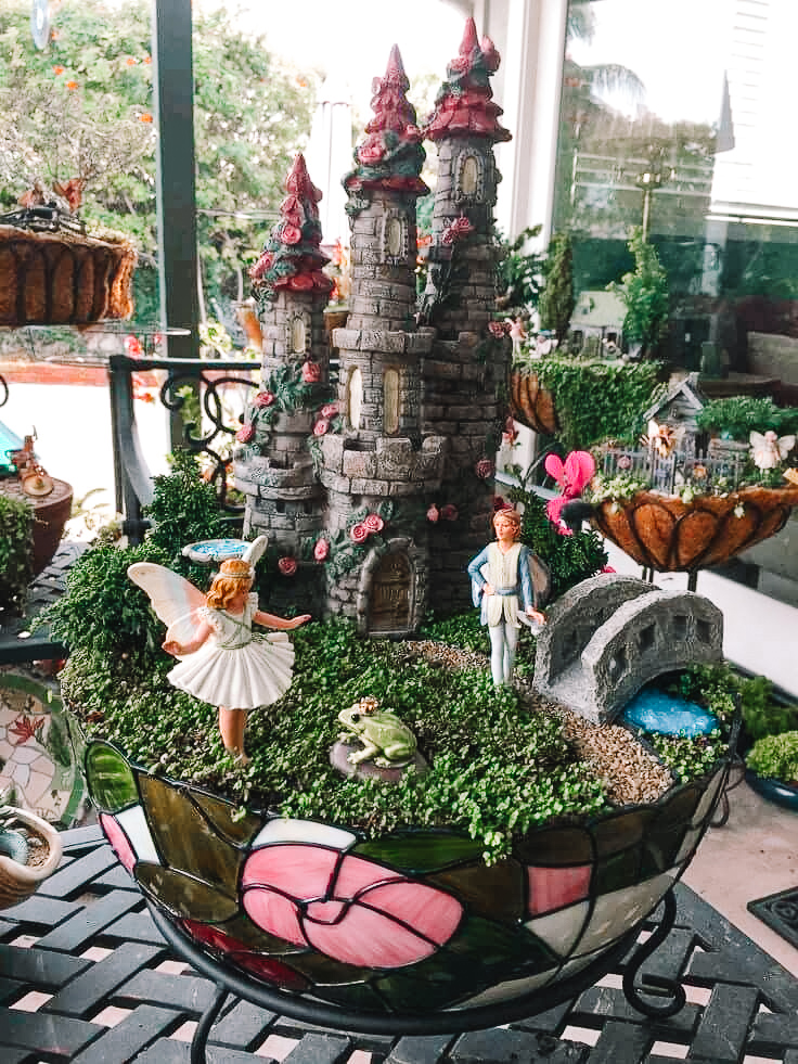mini garden with a castle, fairies, a bridge over a moat and a prince frog